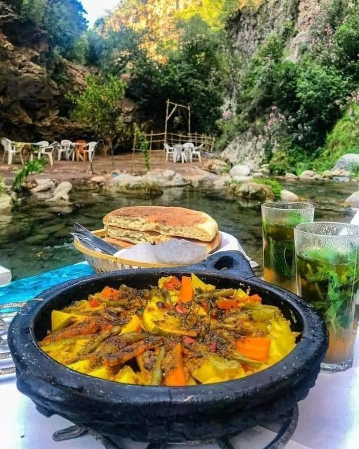 Traditional Moroccan meal served by a riverside café, showing local food experiences travelers can enjoy outside major tourist areas.