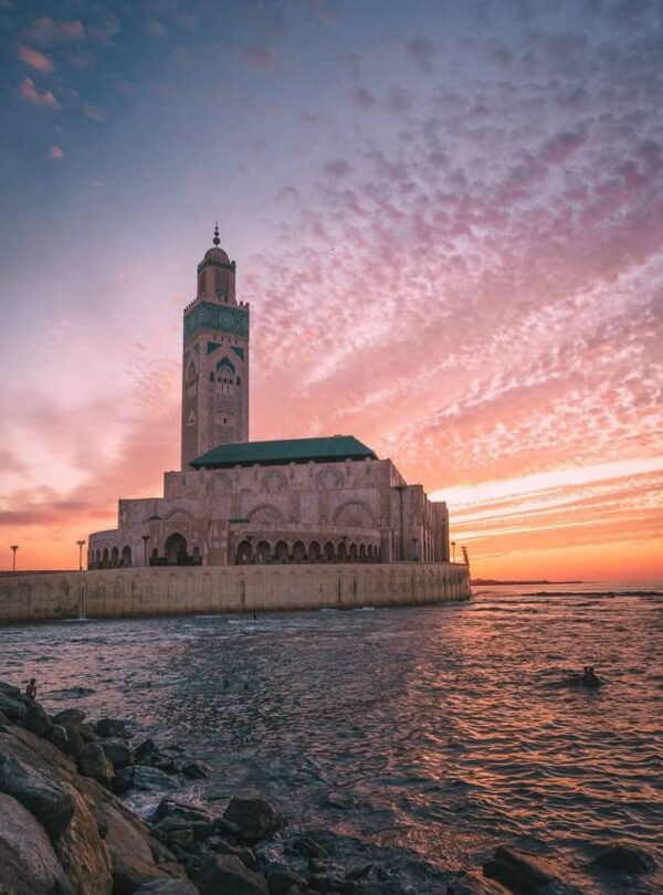 Hassan II Mosque in Casablanca at sunset, overlooking the Atlantic Ocean, a key highlight of Casablanca city tours in Morocco.