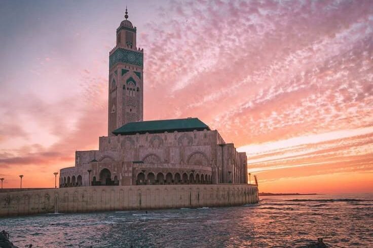 Hassan II Mosque in Casablanca at sunset, overlooking the Atlantic Ocean, a key highlight of Casablanca city tours in Morocco.