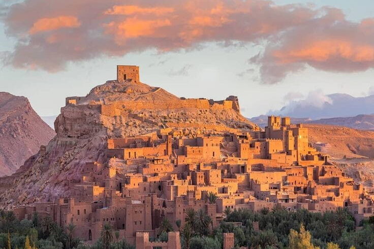 Ait Ben Haddou fortified kasbah at sunset in southern Morocco, popular day trip from Marrakech across the Atlas Mountains.