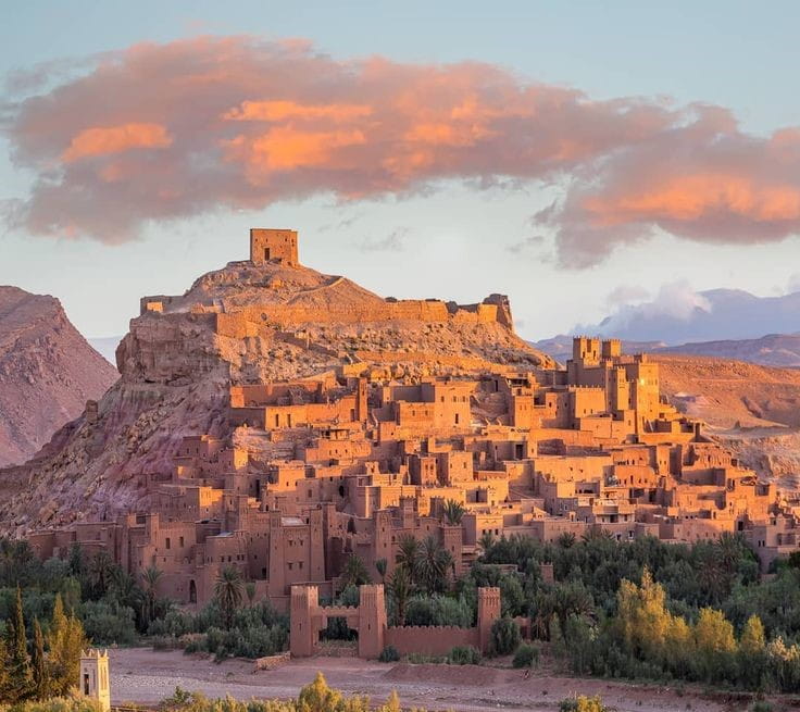 Ait Ben Haddou fortified kasbah at sunset in southern Morocco, popular day trip from Marrakech across the Atlas Mountains.