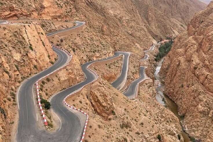 Famous winding road through Dadès Valley surrounded by rocky Atlas landscapes, part of southern Morocco adventure routes.