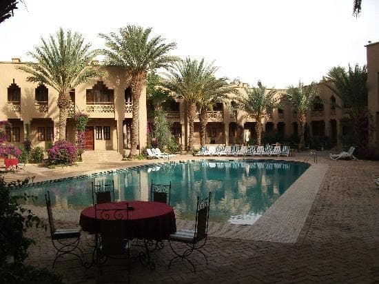 Traditional desert hotel courtyard with swimming pool and palm trees in Erfoud Morocco