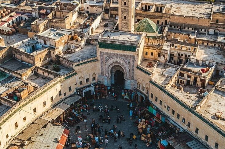 Aerial view of Fes old medina with traditional architecture and historic mosques during a guided Morocco journey.