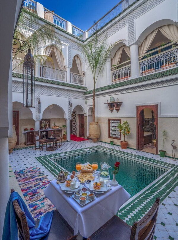 Peaceful riad courtyard with Moroccan breakfast table, typical accommodation during a private Morocco itinerary.