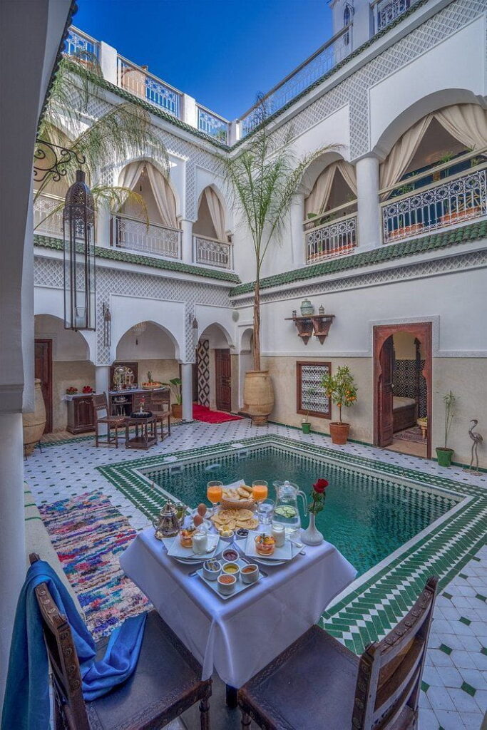Peaceful riad courtyard with Moroccan breakfast table, typical accommodation during a private Morocco itinerary.