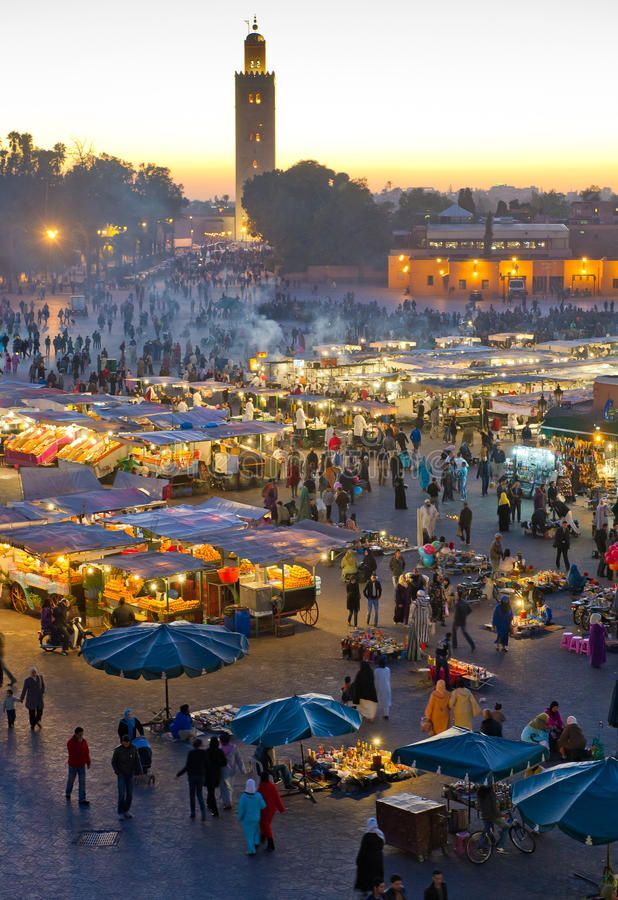 Busy evening atmosphere at Jemaa el-Fna square in Marrakech with food stalls and local performers.