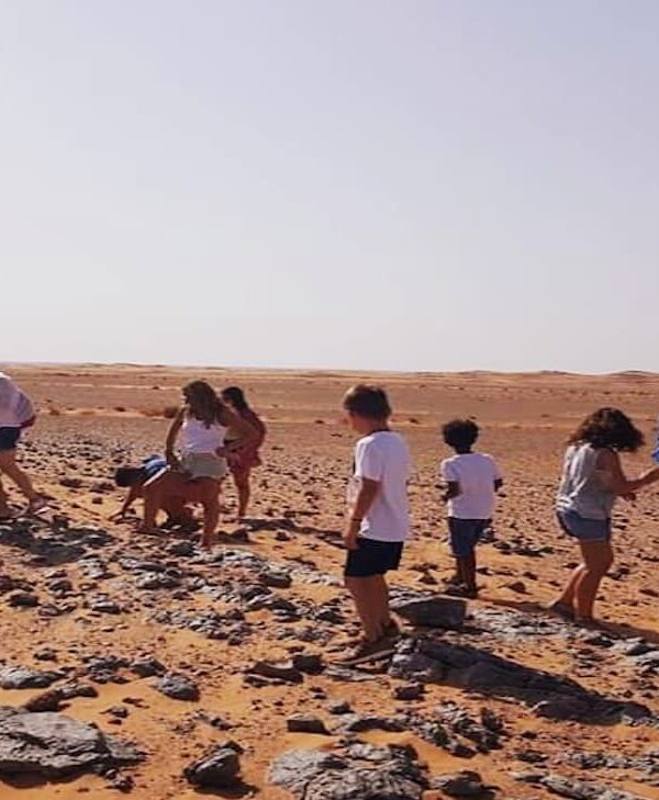 Travelers exploring fossil site during 4x4 desert excursion near Merzouga Sahara Morocco