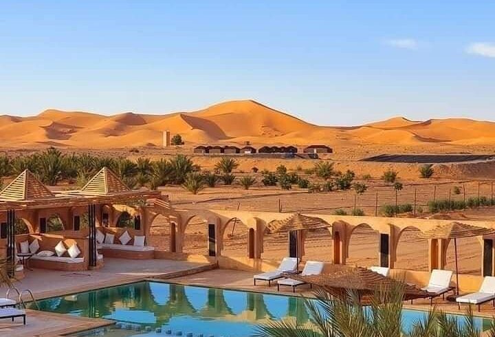 Luxury desert hotel with swimming pool overlooking Erg Chebbi dunes in Merzouga Morocco