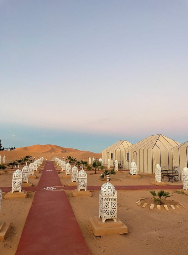 Elegant lantern walkway leading to a luxury desert camp in Merzouga during a Sahara overnight experience.