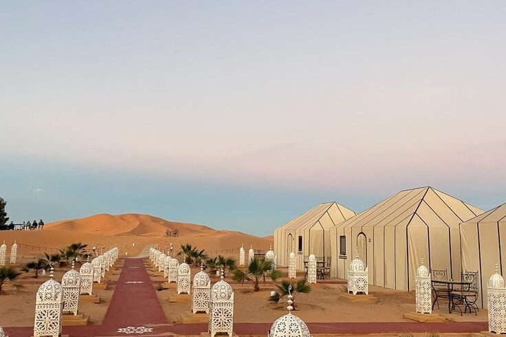 Elegant lantern walkway leading to a luxury desert camp in Merzouga during a Sahara overnight experience.