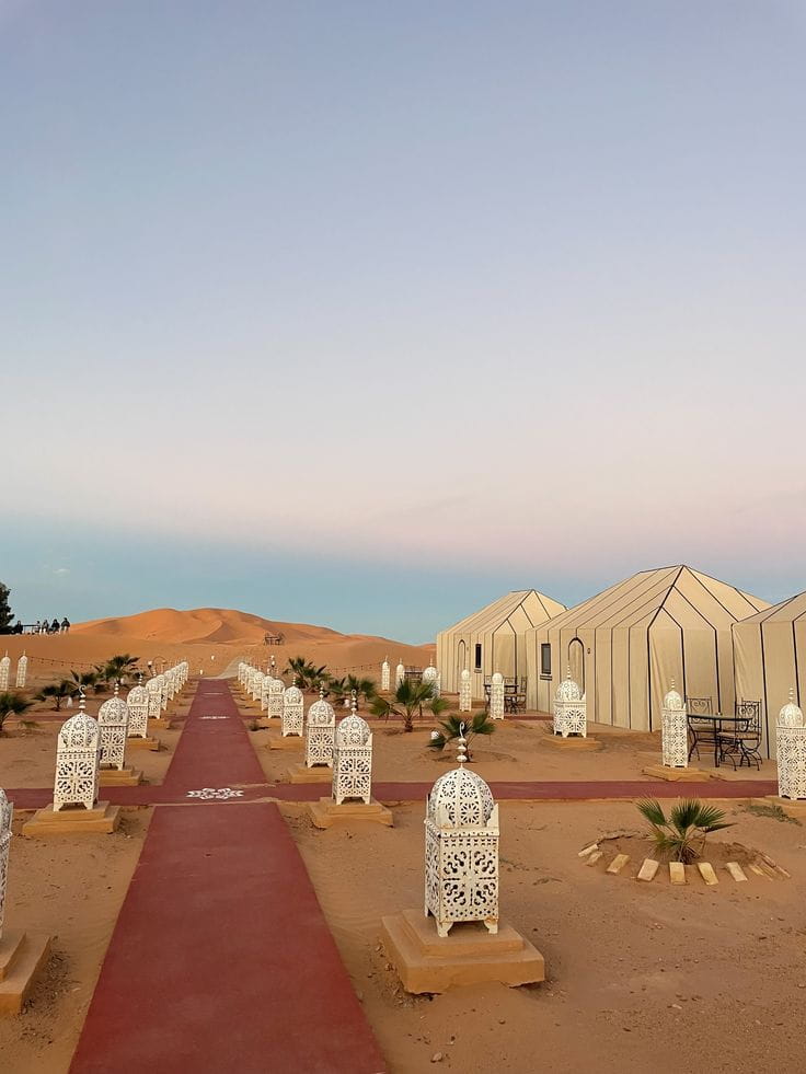 Elegant lantern walkway leading to a luxury desert camp in Merzouga during a Sahara overnight experience.