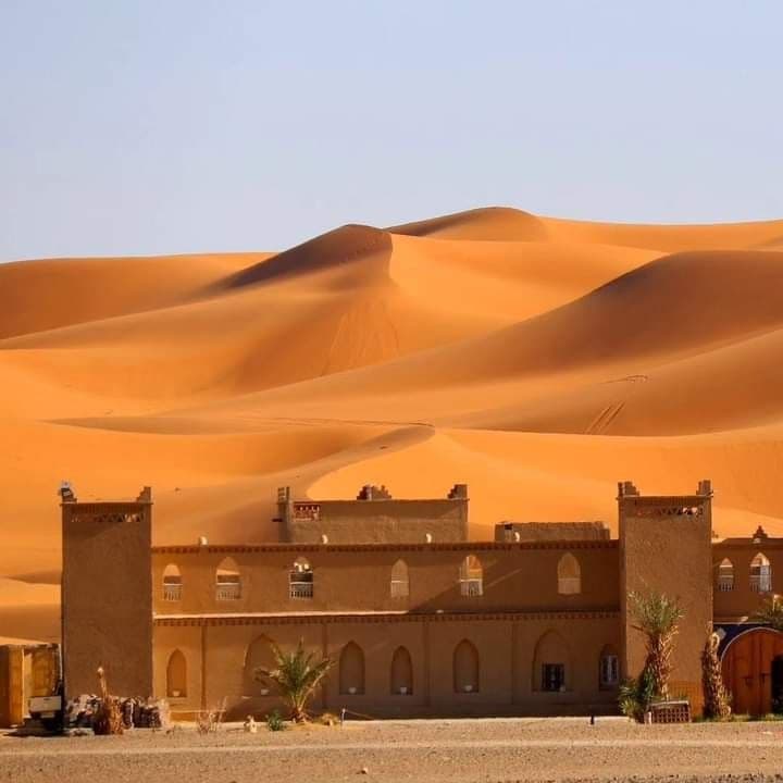 Desert camp at the foot of golden Erg Chebbi dunes in Merzouga Sahara Morocco