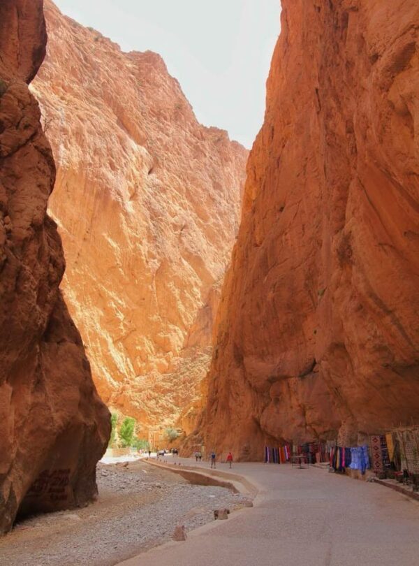Visitors walking between towering canyon walls at Todra Gorges near Tinghir Morocco