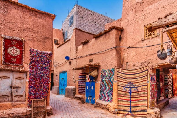 Colorful traditional carpets displayed in narrow streets of Fes Medina Morocco