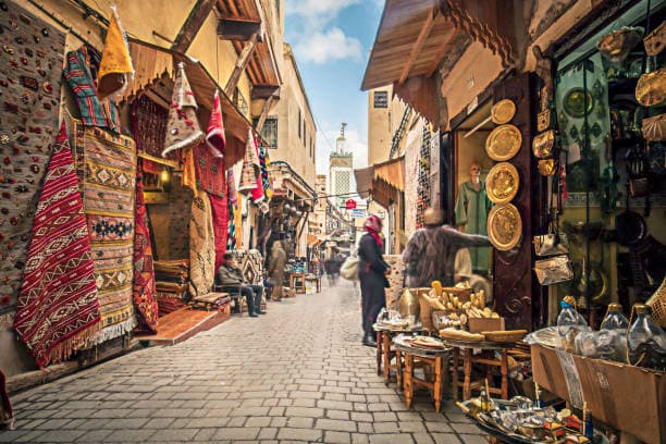 Traditional souk street with handmade crafts and carpets in Fes Medina Morocco